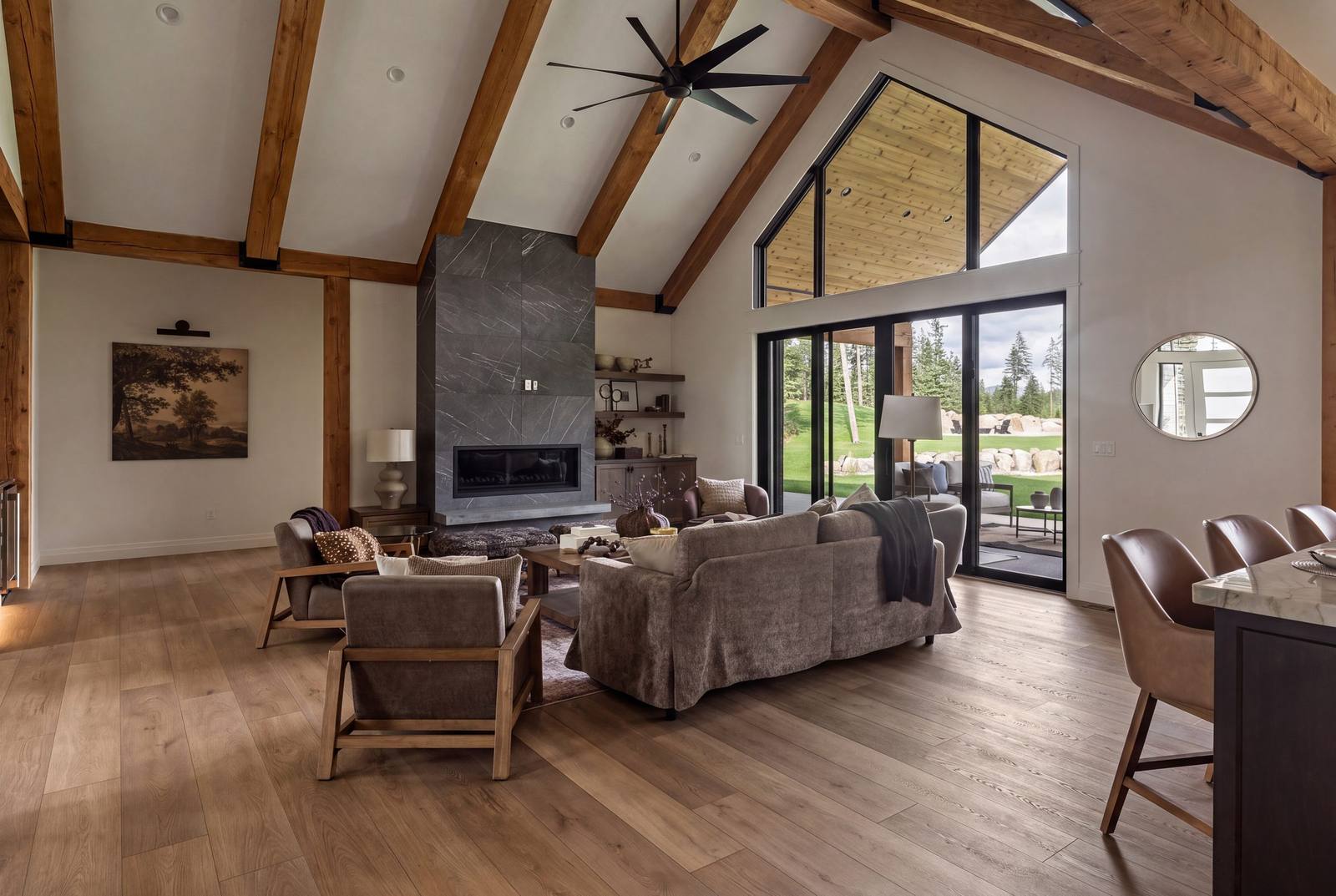 Vaulted great room with exposed timber trusses and a floor-to-ceiling stone fireplace