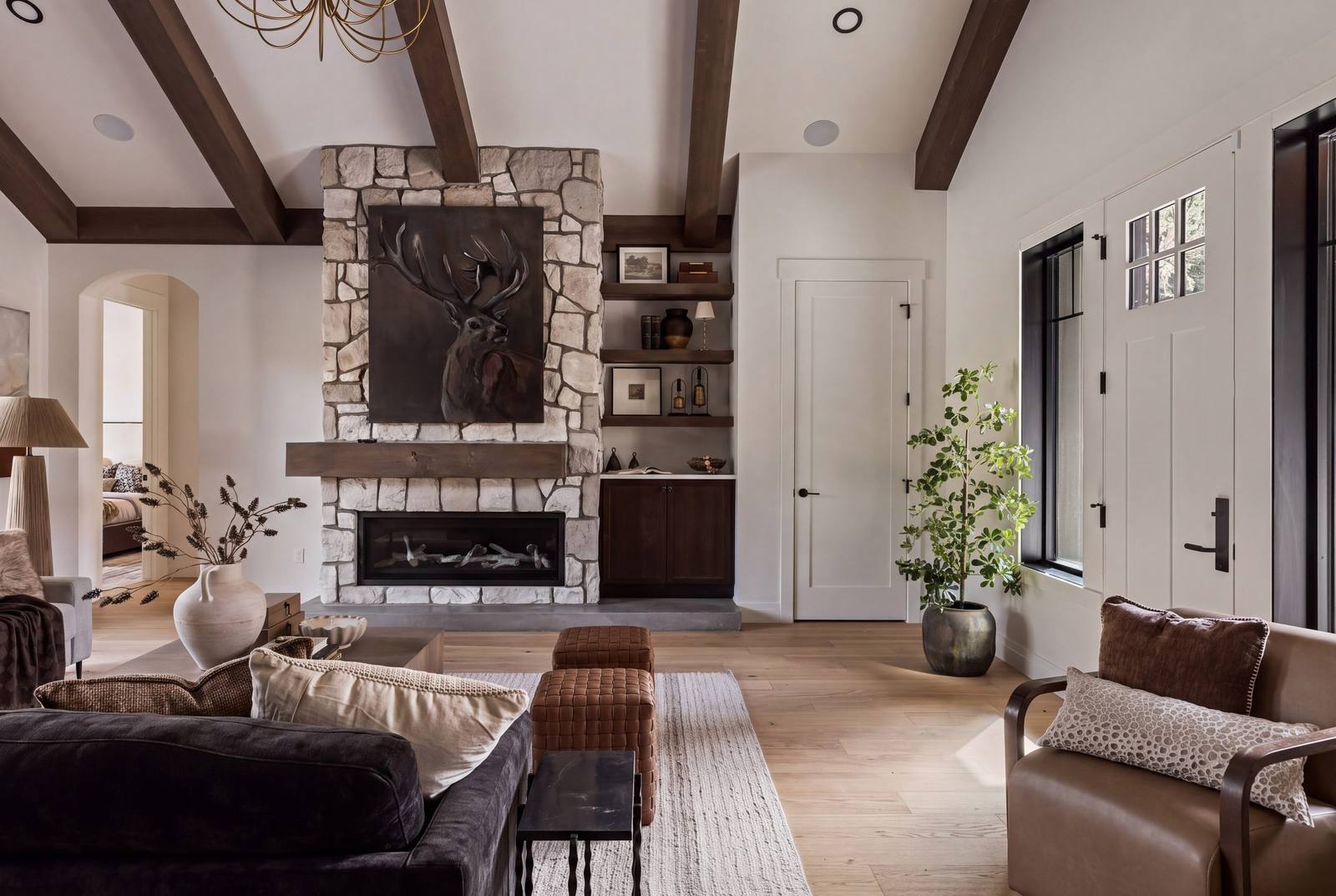 Vaulted living room with cedar beam wraps and a floor-to-ridge stone fireplace
